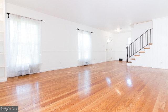 unfurnished living room with light wood-type flooring and plenty of natural light