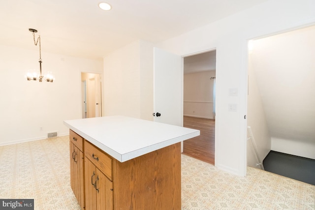 kitchen with pendant lighting, light hardwood / wood-style floors, and a center island