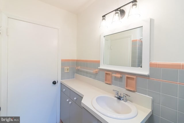 bathroom featuring vanity and tile walls