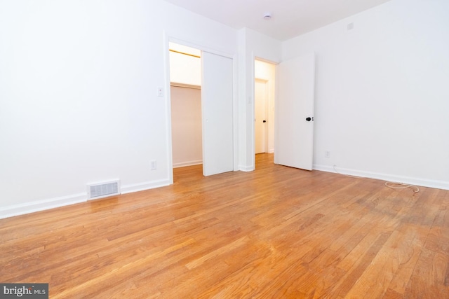 unfurnished bedroom featuring light hardwood / wood-style flooring and a closet