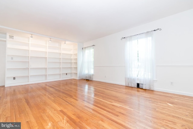 unfurnished room with light hardwood / wood-style flooring, a wealth of natural light, and track lighting