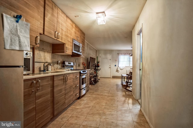 kitchen featuring backsplash, sink, light tile patterned floors, and stainless steel appliances