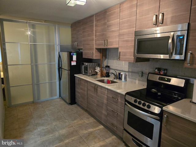 kitchen featuring backsplash, sink, and stainless steel appliances