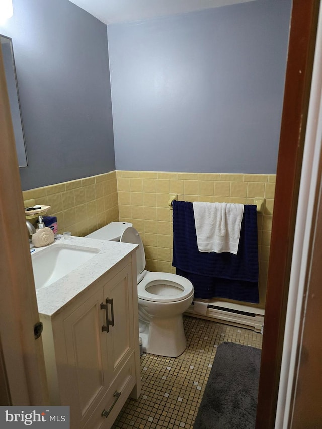 bathroom featuring vanity, tile patterned floors, toilet, tile walls, and a baseboard radiator