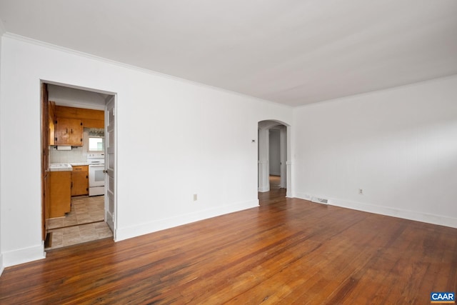 empty room featuring ornamental molding and hardwood / wood-style flooring