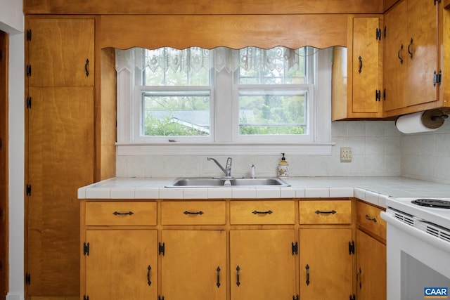 kitchen featuring decorative backsplash, tile counters, sink, and plenty of natural light