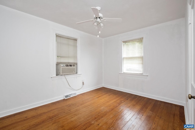 empty room featuring cooling unit, ceiling fan, and hardwood / wood-style flooring