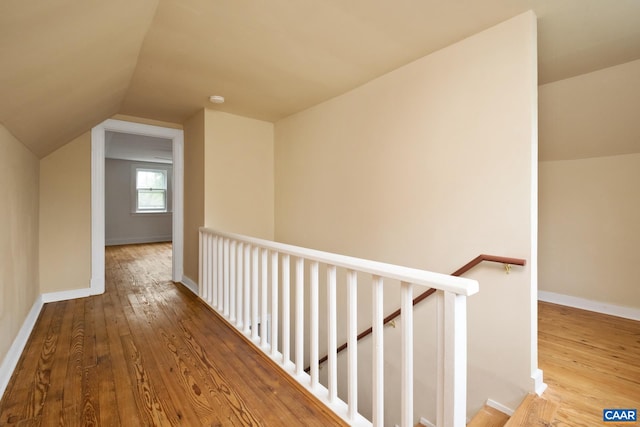 hall featuring vaulted ceiling and hardwood / wood-style flooring