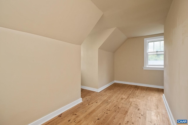 additional living space featuring light hardwood / wood-style flooring and lofted ceiling