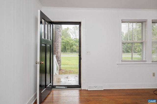 entrance foyer featuring crown molding, hardwood / wood-style floors, and plenty of natural light