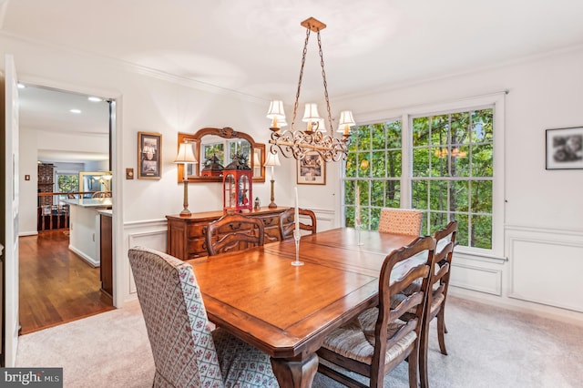 carpeted dining space with crown molding and a chandelier