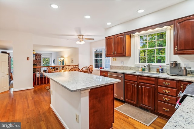 kitchen featuring dark hardwood / wood-style floors, a kitchen island, sink, and stainless steel dishwasher