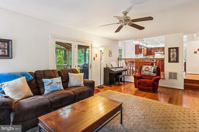 living room featuring ceiling fan and hardwood / wood-style flooring