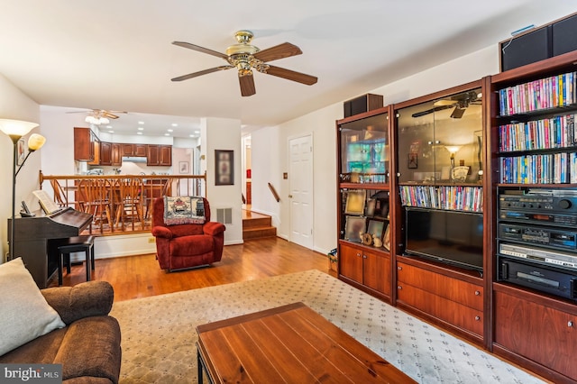 living room featuring light hardwood / wood-style floors and ceiling fan