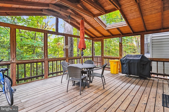 sunroom with a wealth of natural light, wood ceiling, and vaulted ceiling with skylight