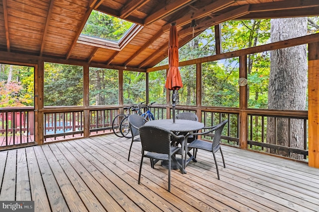 sunroom / solarium with lofted ceiling with skylight and wooden ceiling