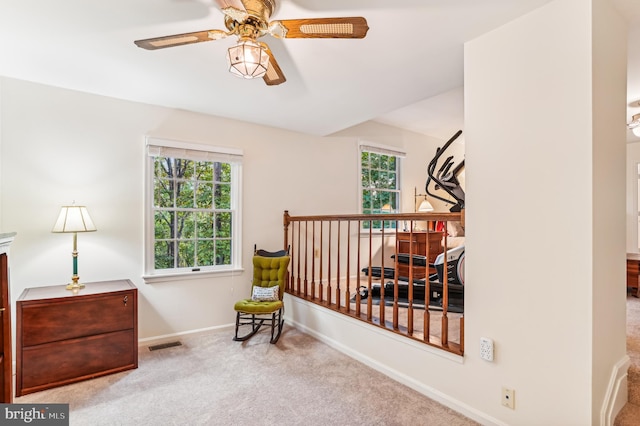 sitting room featuring ceiling fan, light carpet, and a wealth of natural light