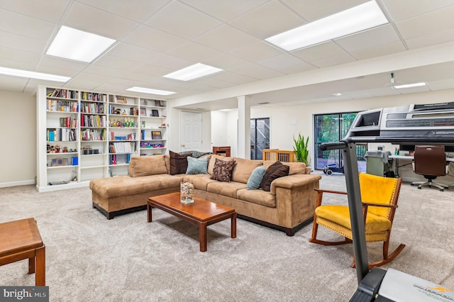 living room featuring light carpet and a paneled ceiling