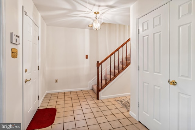 entryway featuring light tile patterned flooring and a notable chandelier