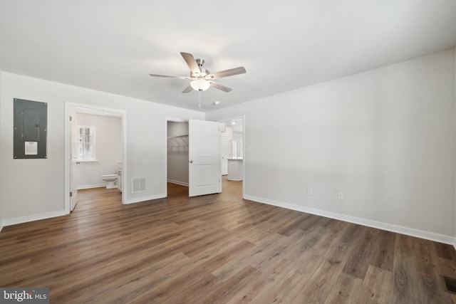 unfurnished bedroom featuring ceiling fan, electric panel, ensuite bathroom, a walk in closet, and a closet