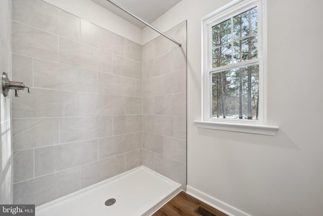 bathroom featuring a tile shower and a wealth of natural light