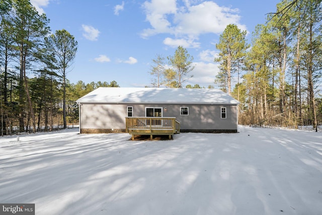 snow covered house featuring a deck