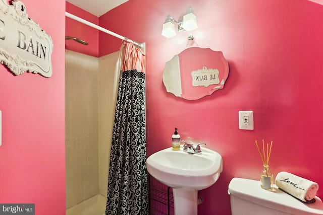 bathroom with a shower with shower curtain and toilet