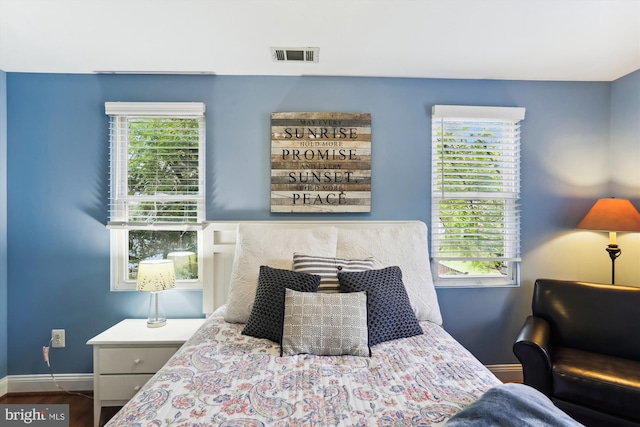 bedroom with multiple windows and wood-type flooring