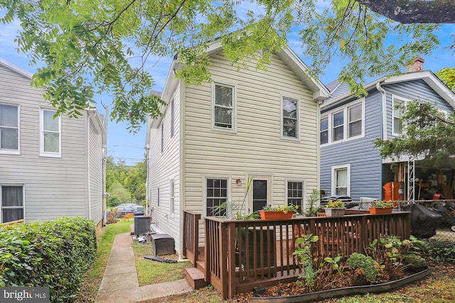 rear view of house with a wooden deck and central AC