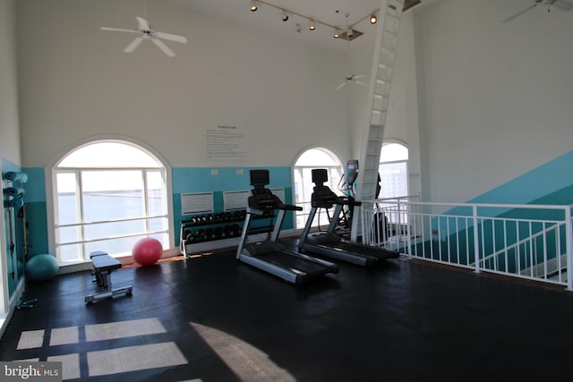 gym with a high ceiling and ceiling fan