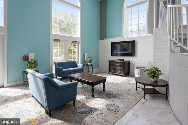 living room with a towering ceiling and a healthy amount of sunlight