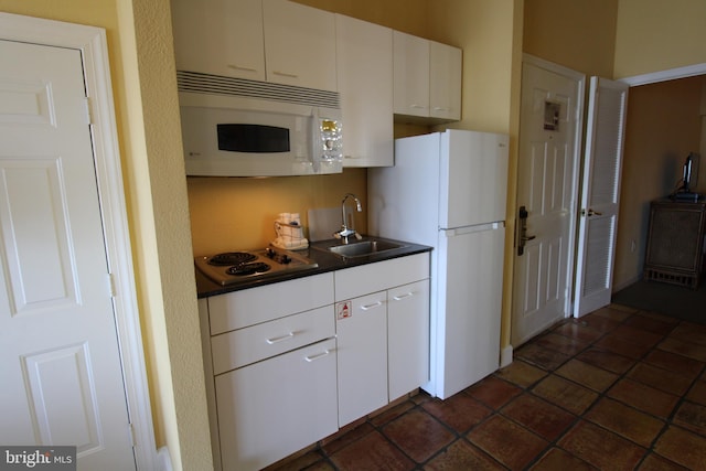 kitchen with white cabinets, sink, and white appliances