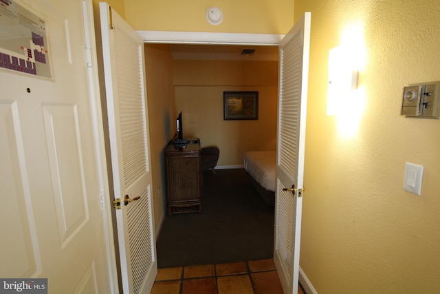 hallway featuring dark tile patterned floors