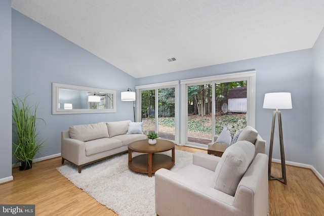 living room featuring light hardwood / wood-style floors and vaulted ceiling