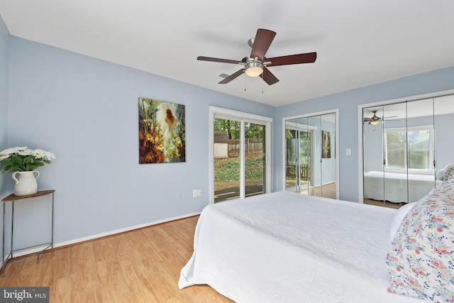 bedroom featuring access to outside, light hardwood / wood-style floors, ceiling fan, and multiple closets