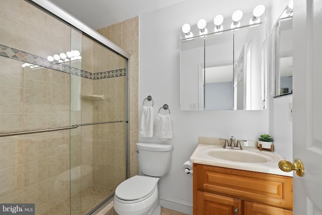 bathroom featuring vanity, toilet, and a shower with door