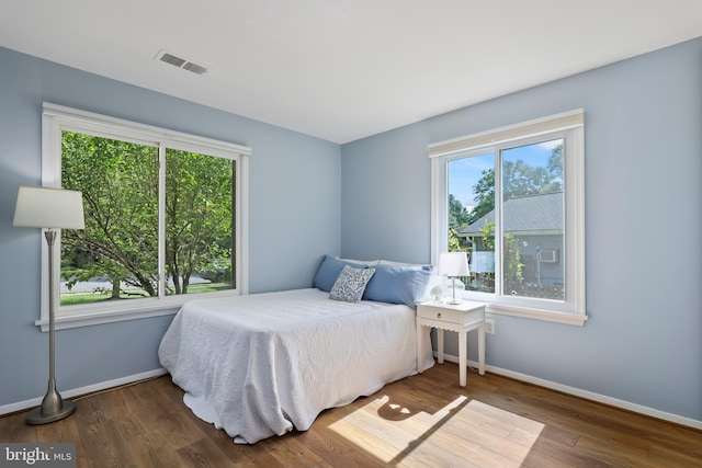 bedroom with dark hardwood / wood-style flooring