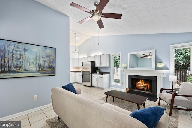 living room featuring ceiling fan, a textured ceiling, high vaulted ceiling, and light tile patterned flooring