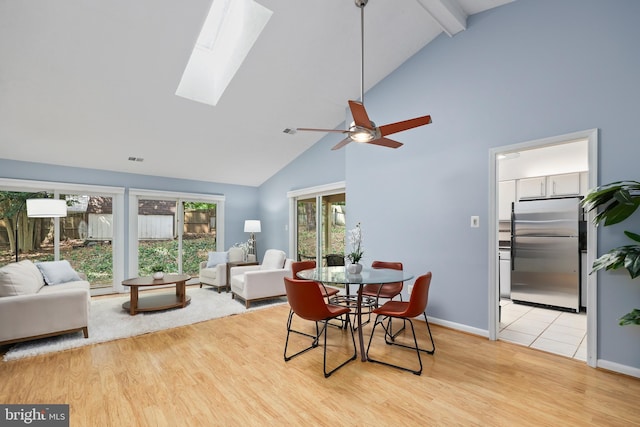 dining space with high vaulted ceiling, a wealth of natural light, and light hardwood / wood-style floors