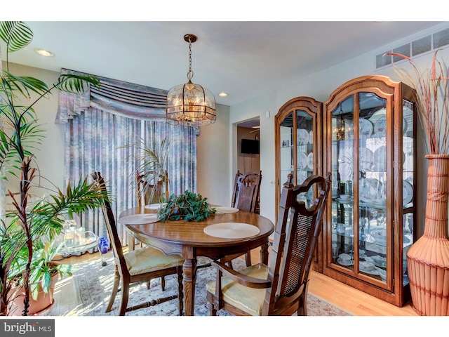 dining space featuring light wood-type flooring and a chandelier