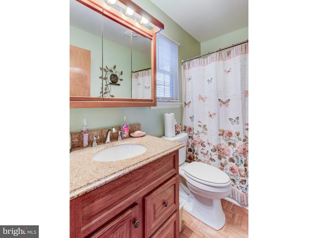 bathroom with parquet floors, vanity, and toilet