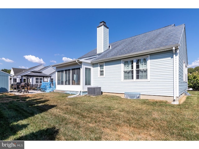 back of house featuring a patio, a yard, and a sunroom