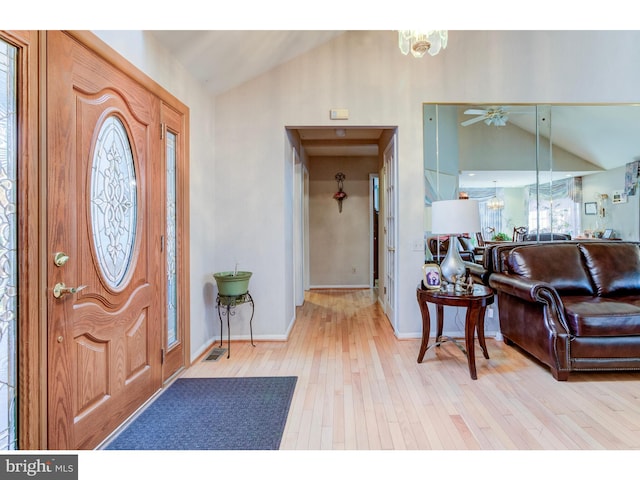 entrance foyer featuring ceiling fan with notable chandelier, lofted ceiling, and hardwood / wood-style flooring