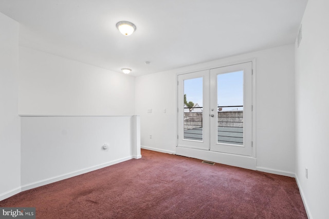 carpeted empty room featuring french doors