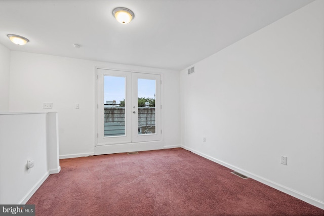 carpeted empty room featuring french doors