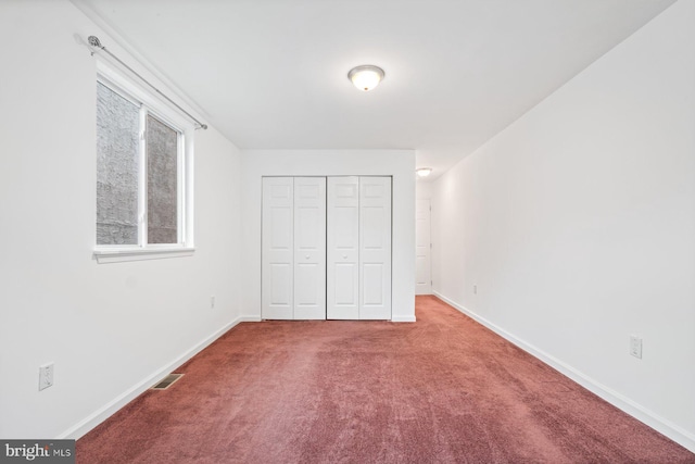 unfurnished bedroom with a closet and carpet floors