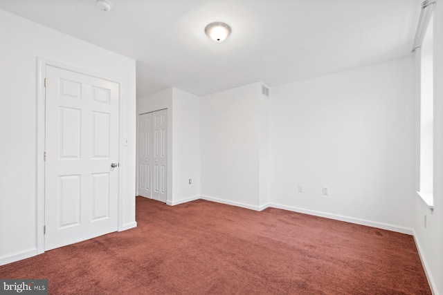 empty room featuring dark colored carpet