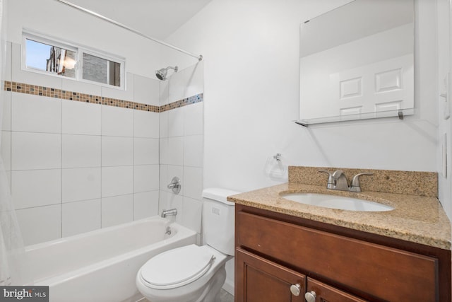 full bathroom featuring tiled shower / bath combo, vanity, and toilet