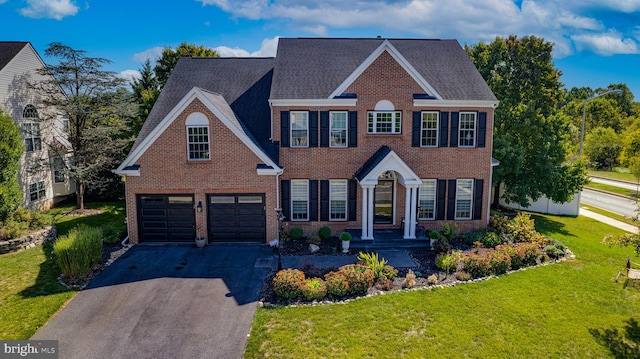 colonial-style house with a front yard and a garage