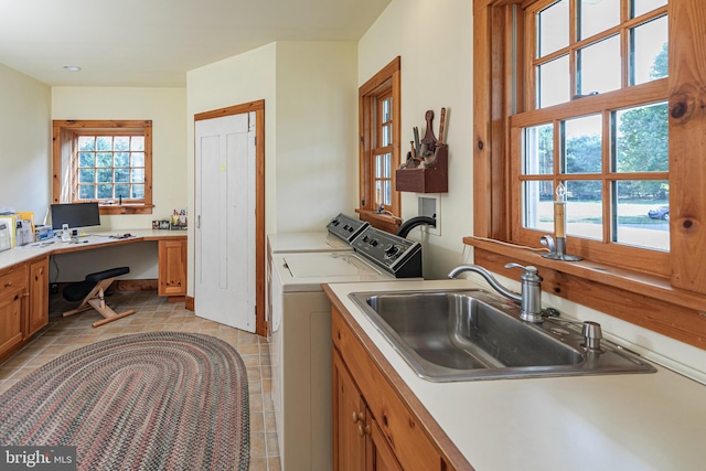 clothes washing area featuring sink, light tile patterned flooring, and washing machine and dryer